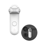 Vitt barnlås för dörrhandtag sedd framifrån, med ett rundat låsblockerande skydd upptill och en knapp på framsidan. I en mindre cirkel bredvid visas hur låset används på en mörk dörr där ett svart dörrhandtag hindras från att tryckas ned av låset.