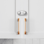 Premium barnlås för dubbeldörrar monterat på vit skåpslucka med handtag.