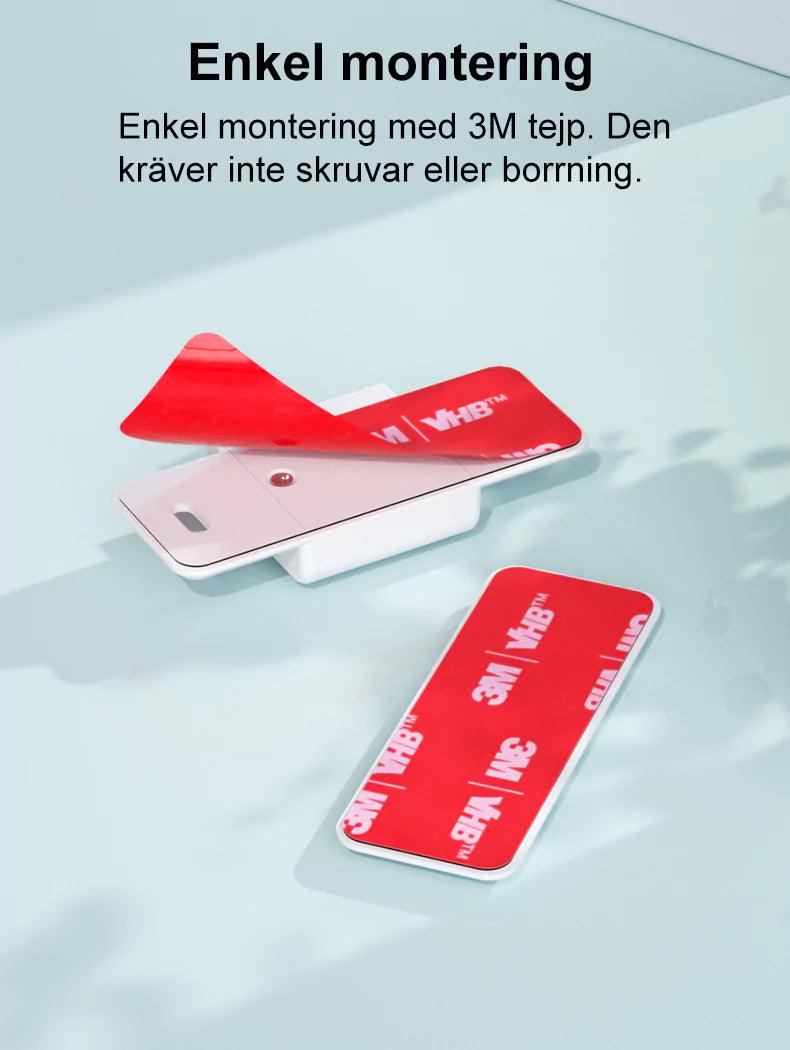 Barnlås för skjutdörr eller skjutfönster som monteras med stark 3M-tejp. Bilden visar låsdelar med röd 3M VHB-tejp där skyddsfilmen dras bort inför montering.