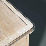 Transparent kantskydd monterat längs kanten på en ljus träbordsskiva för att skydda mot vassa hörn.