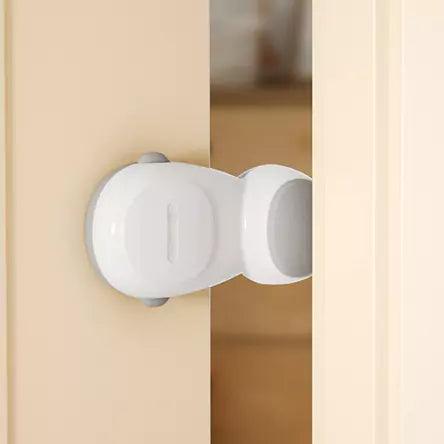 Vitt automatiskt klämskydd monterat mellan dörr och dörrkarm, som hindrar dörren från att stängas helt.