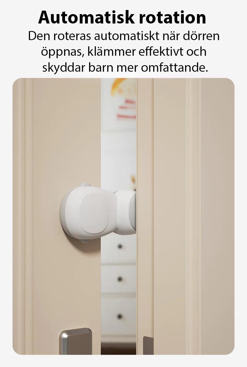 Ett vitt automatiskt dörrklämskydd monterat på en beige dörrkarm. Skyddet visas i aktiverat läge när dörren öppnas, där det roterar och förhindrar att fingrar kan klämmas i glipan mellan dörr och karm.