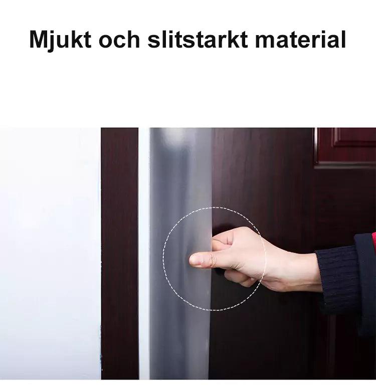 Hand som trycker på ett mjukt och slitstarkt genomskinligt klämskydd monterat på dörrens bakkant.