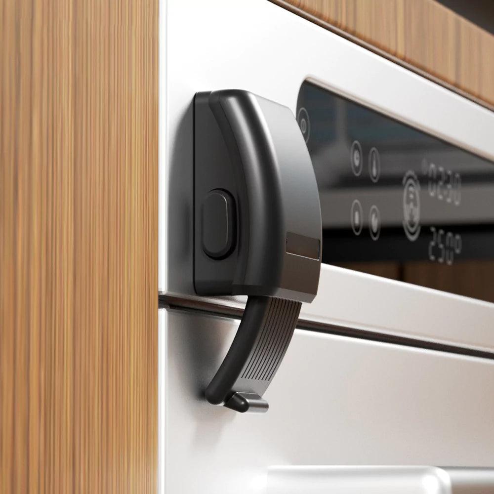 Barnsäkert ugnslås i svart monterat på ugnslucka för att förhindra att barn öppnar en varm ugn.