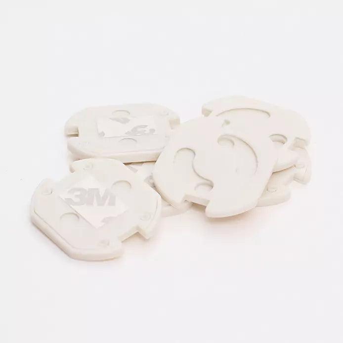 Vita vridbara petskydd för eluttag med självhäftande 3M-tejp, staplade i en grupp.