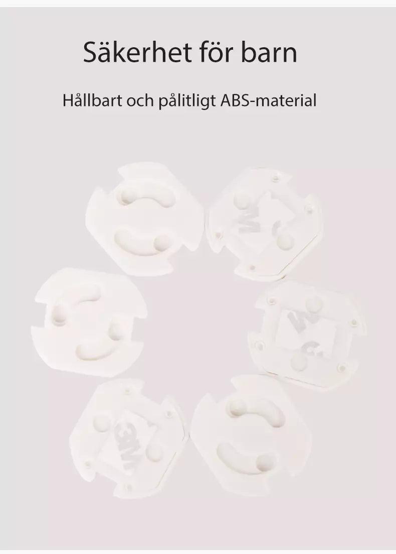 Vita vridbara petskydd för eluttag placerade i en cirkel, med texten ‘Säkerhet för barn – Hållbart och pålitligt ABS-material’ ovanför.